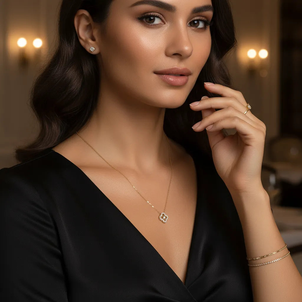 Fotografia zachytáva náhrdelník CREYO FLORÉ zo 14-karátového žltého zlata so štvorlístkovým príveskom zdobeným drobnými kubickými zirkónmi. Hladká článková retiazka a lesklý kameňový detail vytvárajú romantický a jemný vzhľad.