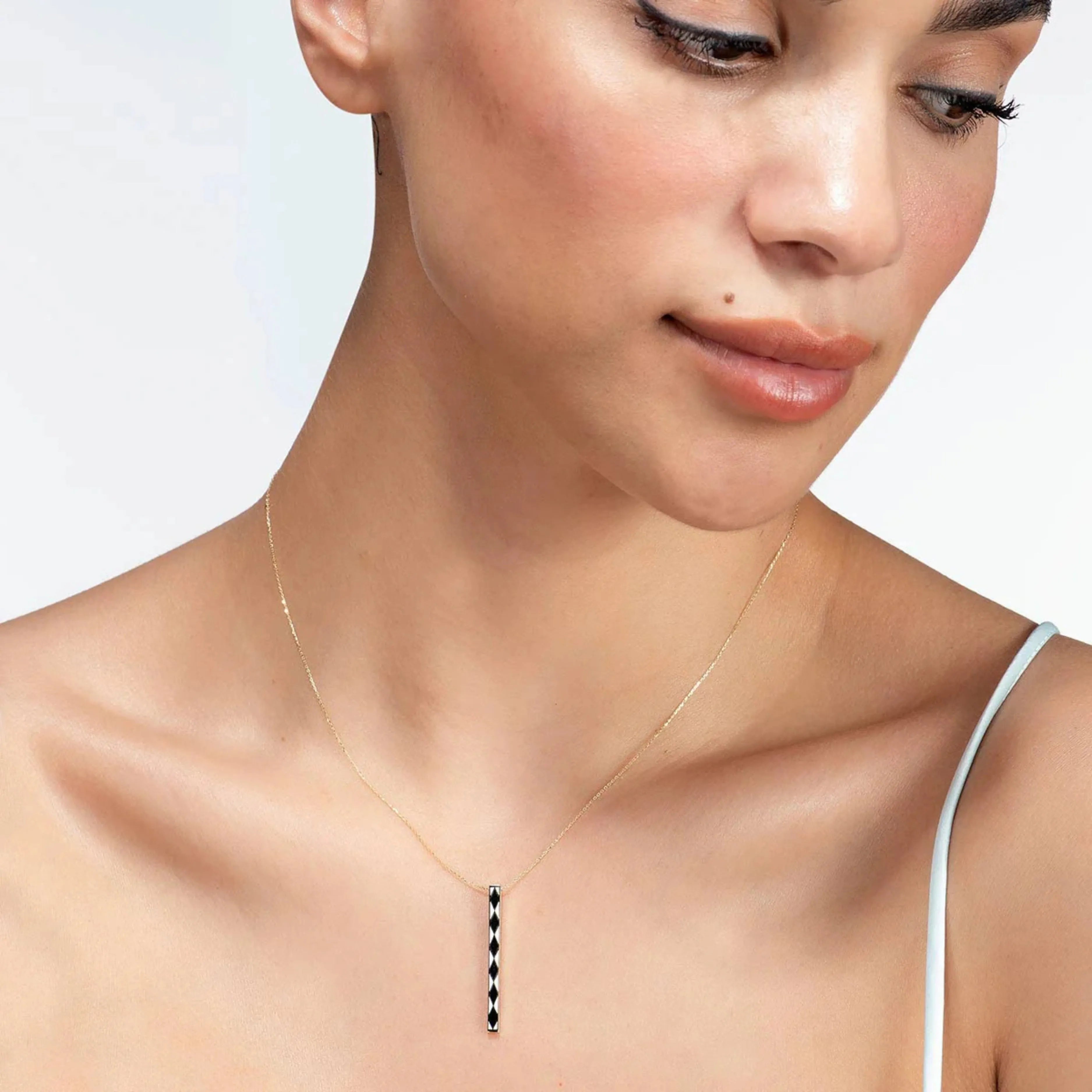 Modelka s elegantným zlatým náhrdelníkom CREYO NOIR s čiernymi vzormi