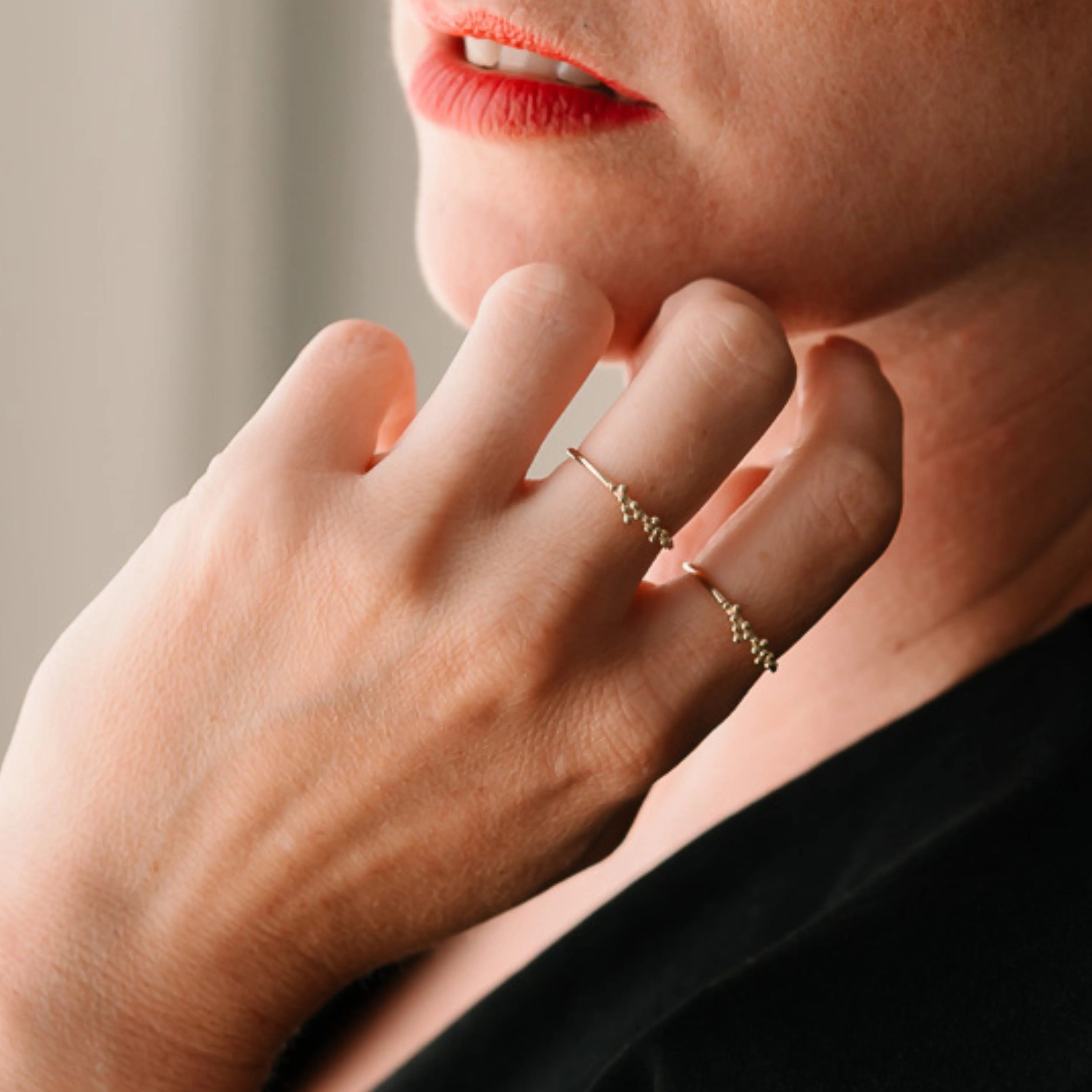 Detailný záber na zlatý prsteň s guľôčkami pri tvári ženy – CREYO DOTS