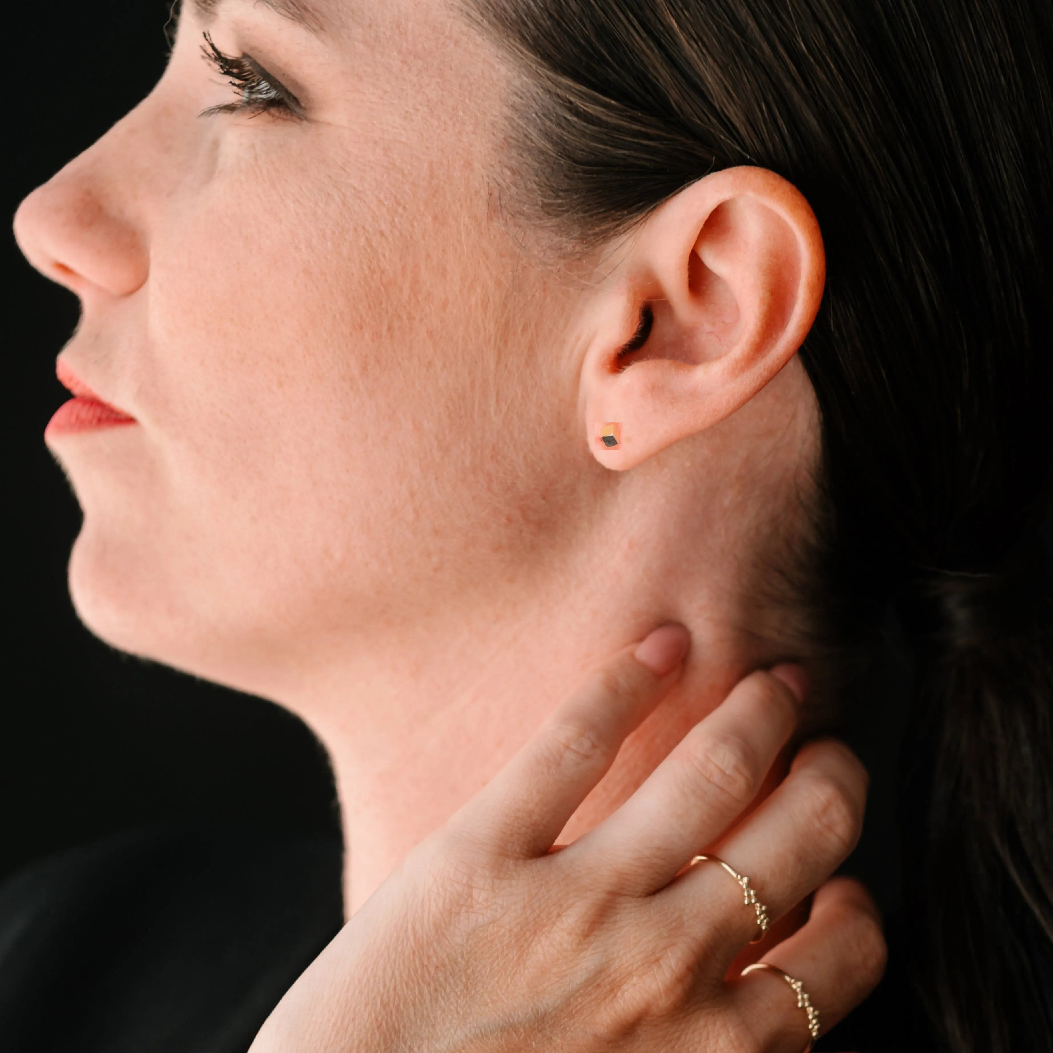 Elegantné zlaté náušnice CREYO CUBICA na modelke