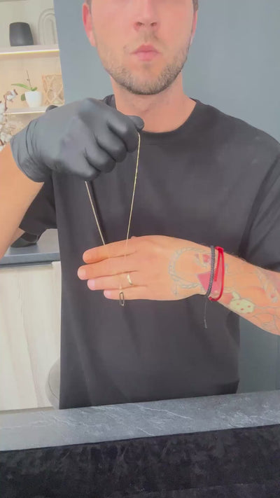 Detailné zábery na náhrdelník CREYO LUNARIA B zo 14-karátového žltého zlata. Video ukazuje jemnú článkovú retiazku a hladký oválny prívesok s vysokým leskom. Šperk sa vo videu leskne v mäkkom svetle a pôsobí minimalisticky a elegantne. Náhrdelník je prezentovaný ako moderný doplnok vhodný na každodenné nosenie aj vrstvenie.