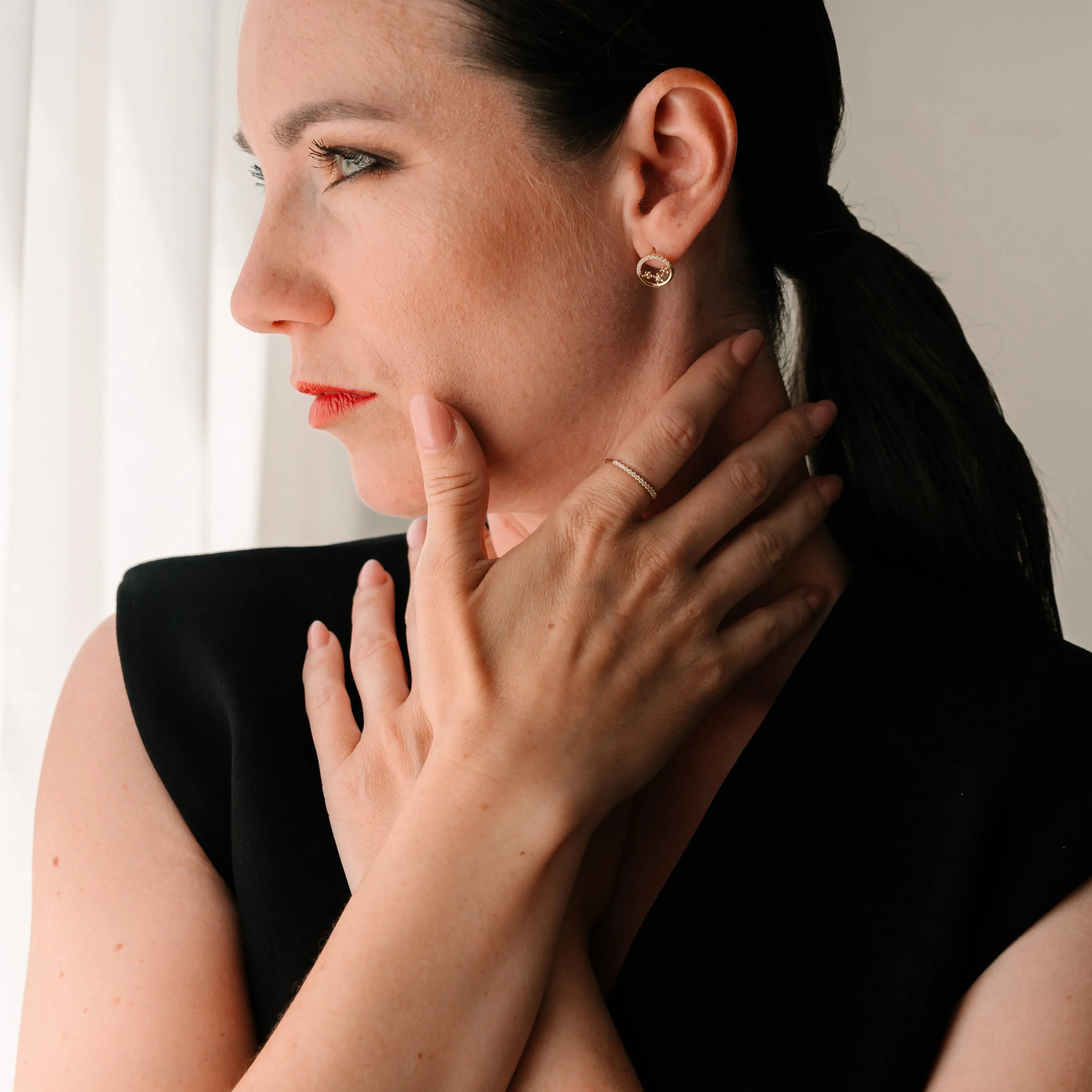 Elegantná žena nosí zlatý prsteň a náušnice CREYO – minimalistický štýl